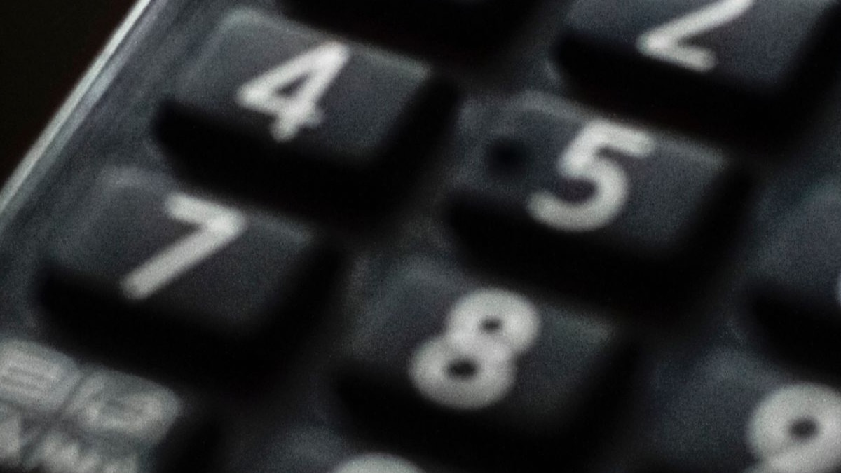Close-up of a TV remote control on a glossy surface, representing Fire TV subtitle settings.